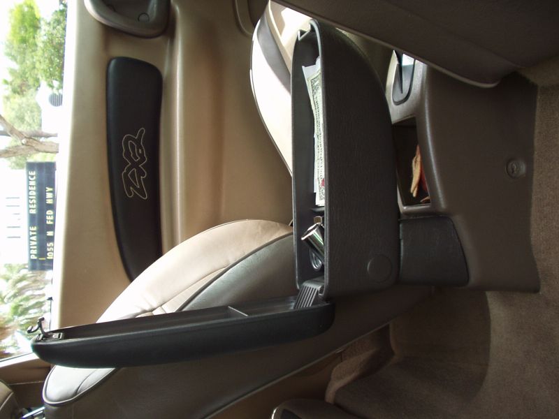 The armrest lid flipped open, showing a storage bin