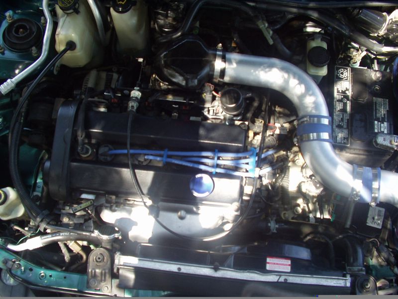 ZX2 engine bay with a silver aftermarket intake tube, blue silicone couplers and blue spark plug wires
