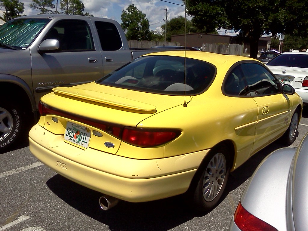 Yellow ZX2 S/R from the rear three-quarter, showing the S/R badge, rear spoiler and alloy wheels